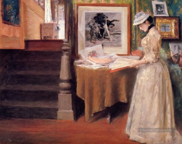 Intérieur de la jeune femme à une table William Merritt Chase Peinture à l'huile